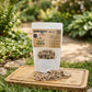 A stand-up pouch labeled 'SHERLOCK'S PET & CO Reward Coins' with many small round dog treat coins spilled in front on a wooden surface against a white background.