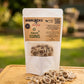 A stand-up pouch labeled 'SHERLOCK'S PET & Co Reward Coins' with many small round beige-and-brown ring-shaped treats spilled in front, set on a wooden board against a white backdrop.