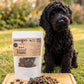 A stand-up pouch labeled 'SHERLOCK'S PET CO. Fruit N Veg STARS' stands on a wooden tray with a pile of star-shaped pet treats in front.